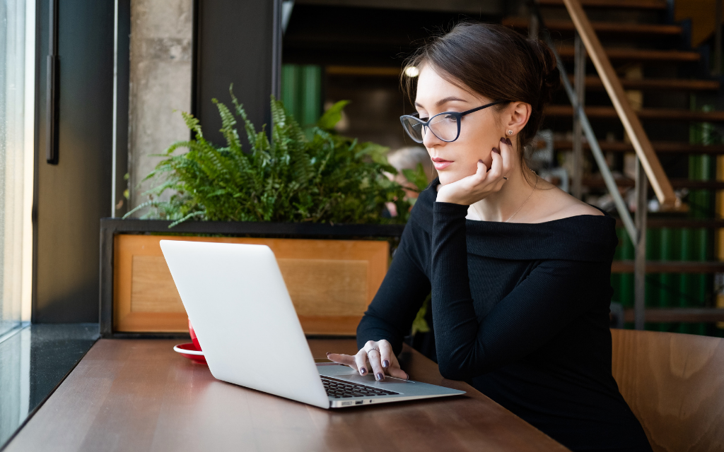 a woman watching a laptop at the cafe